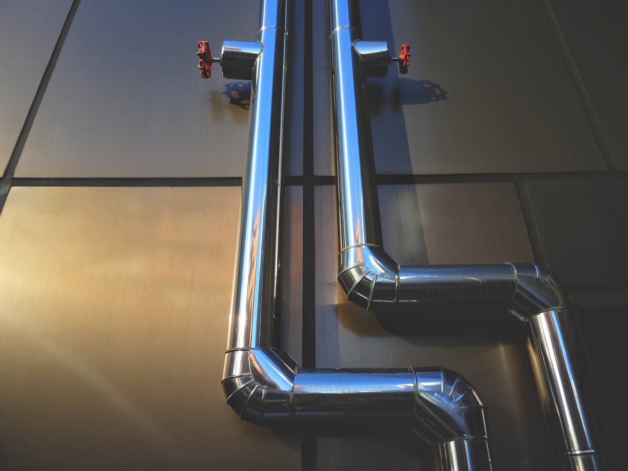 creative-02 Close-up view of industrial steel pipes with valves on a metallic background, showcasing architecture.