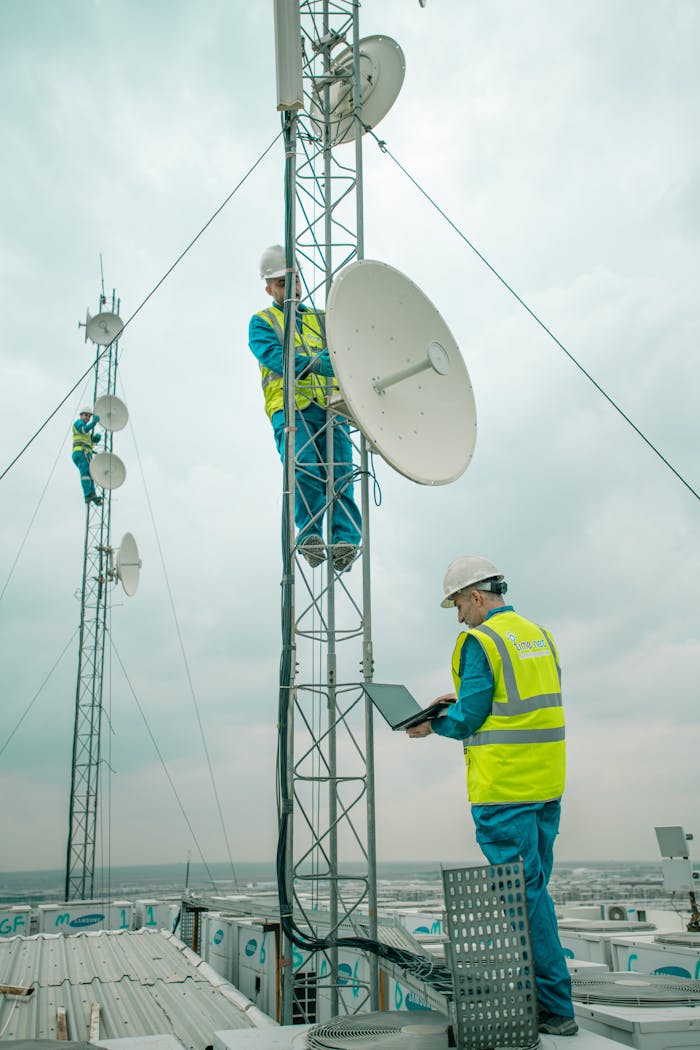 creative-02 Workers in reflective vests install satellite dishes on towers in Shaqlawa, Iraq.