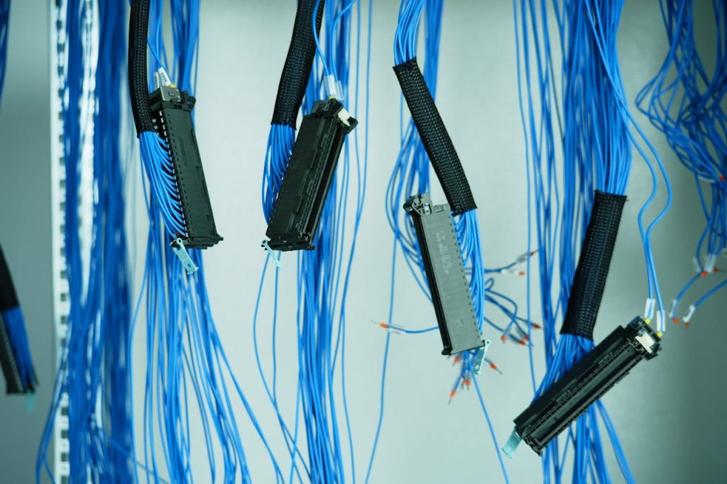 Close-up of blue ethernet cables hanging in a data center, highlighting technology connections.