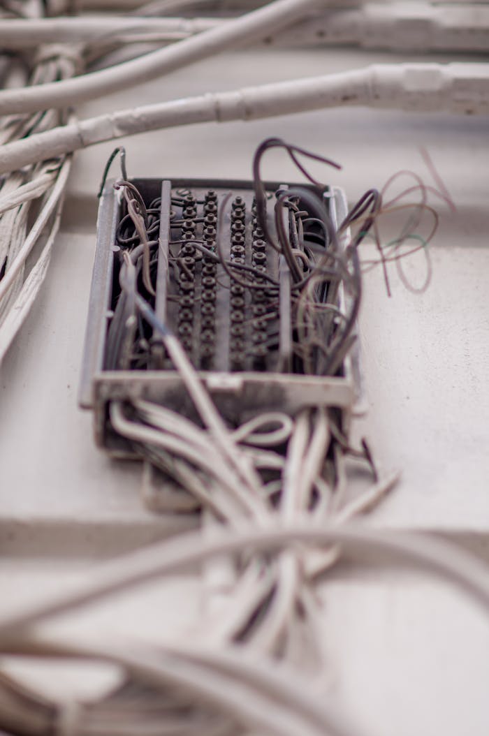 digital-01 Detailed view of a tangled network of wires in a junction box, illustrating complex wiring.