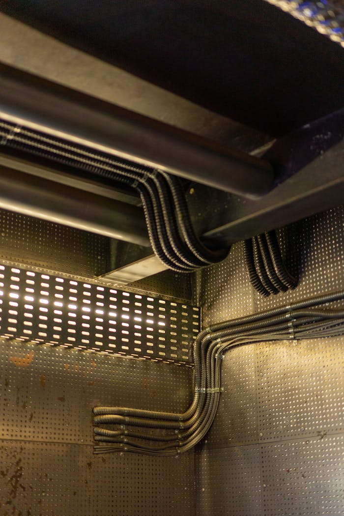 A close-up view of industrial pipes and wires in a metallic room, illustrating modern engineering.